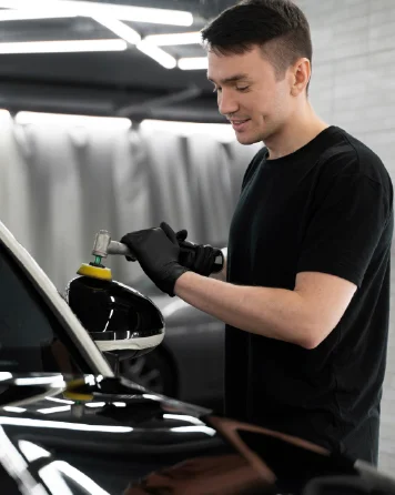 Technician polishing a car with a machine polisher