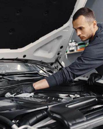Technician applying paint protection film to a car