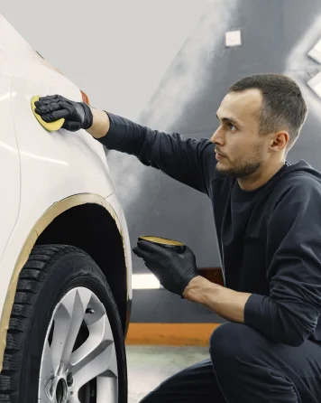 Hands applying ceramic coating to a car panel